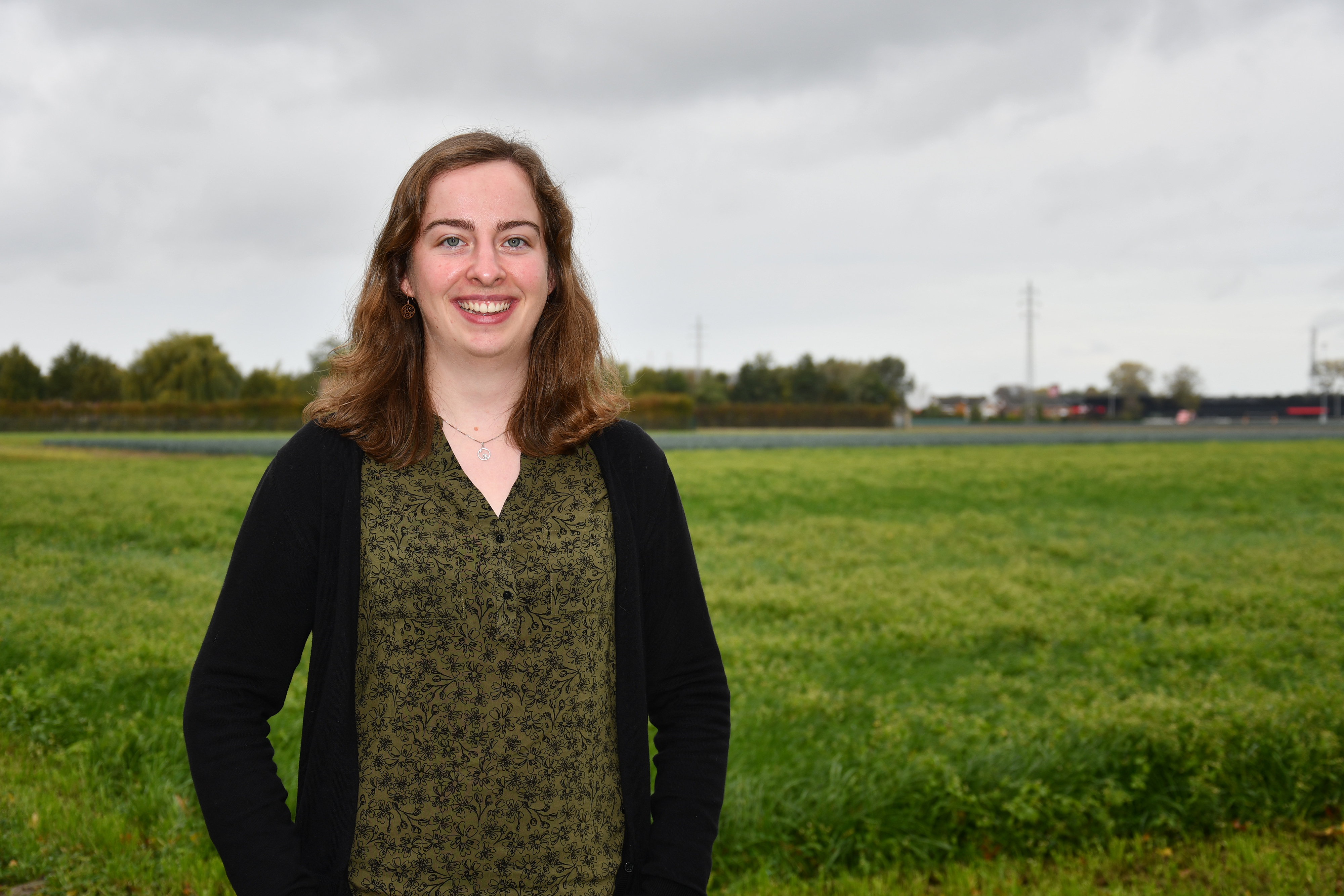 Vrouw staat voor een grasveld