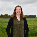 Vrouw staat voor een grasveld