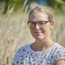 vrouw zit neer tussen gras