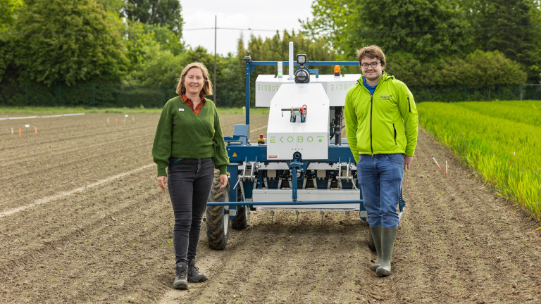 Ekobot op het veld met aan weerszijde onderzoekers
