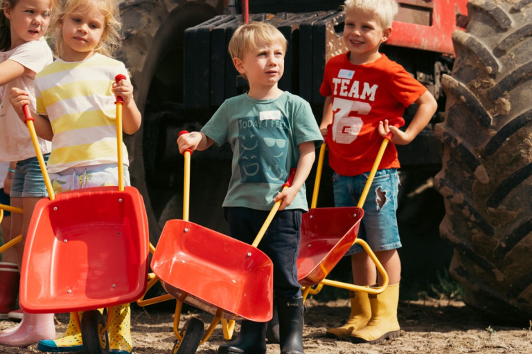 Kinderen met kruiwagens voor tractor
