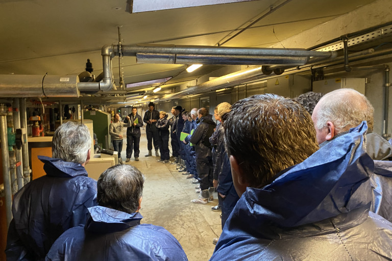 Uitleg bij de technische ruimte in de gang van de stallen.