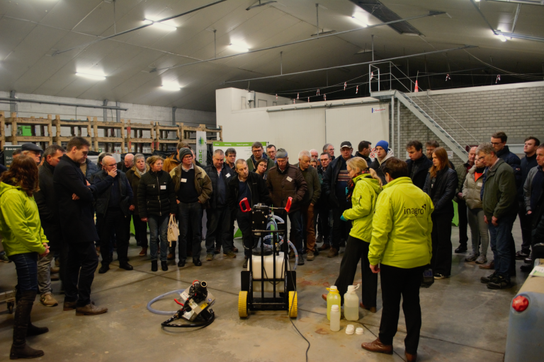 Mensen kijken naar demo op studieavond witloof in de witloofloods