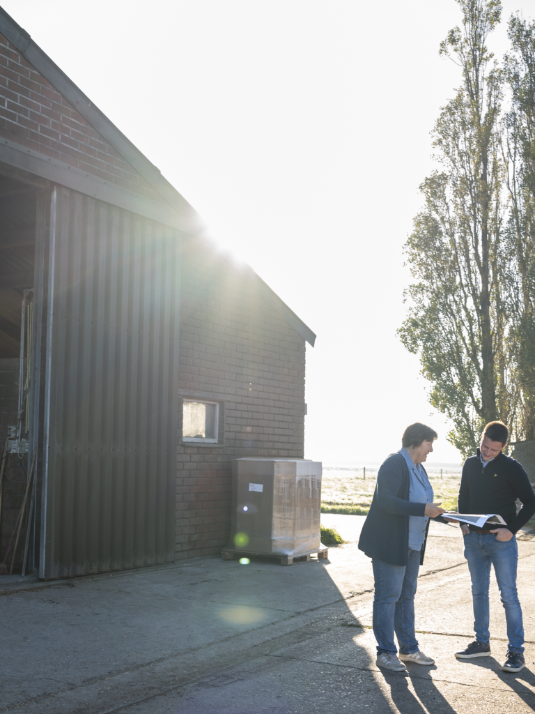 Kathleen geeft advies aan landbouwer Simon buiten de stal.